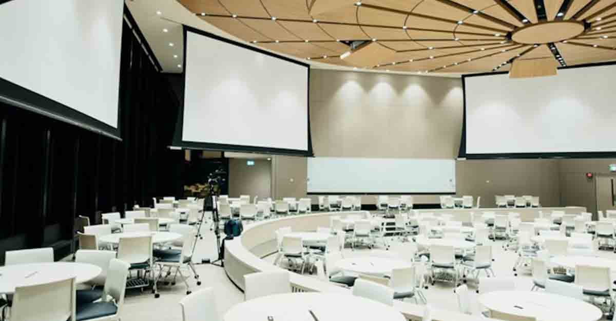 Conference room expertly arranged by event management, featuring sleek screens, organized tables, and comfortable chairs.