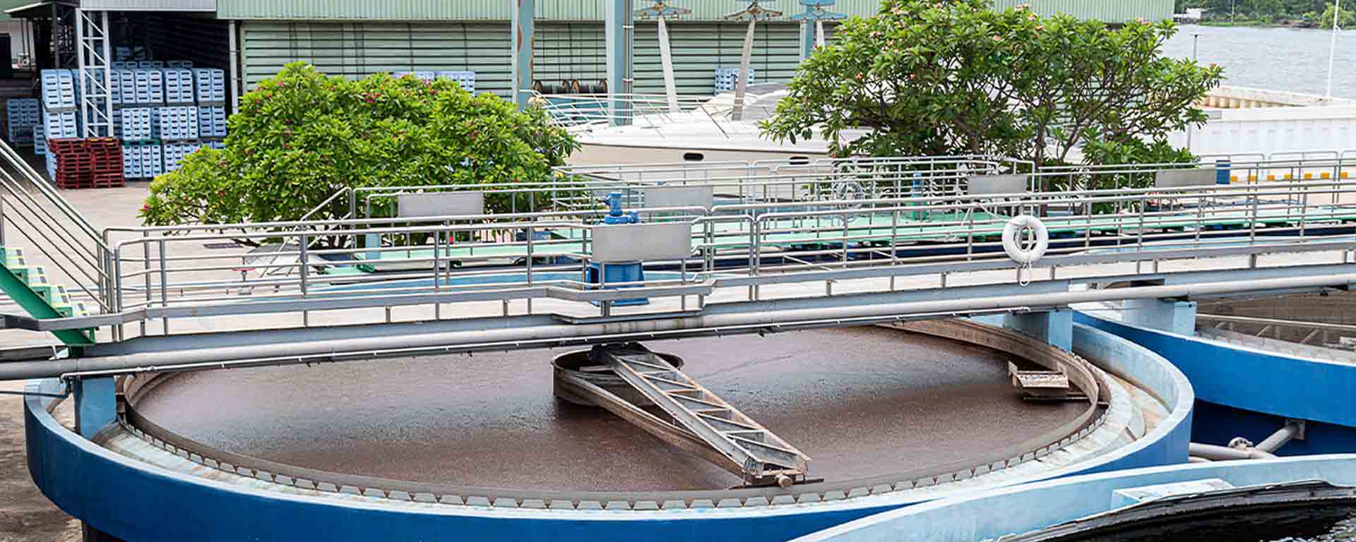 Industrial water treatment facility with a large circular clarifier system.